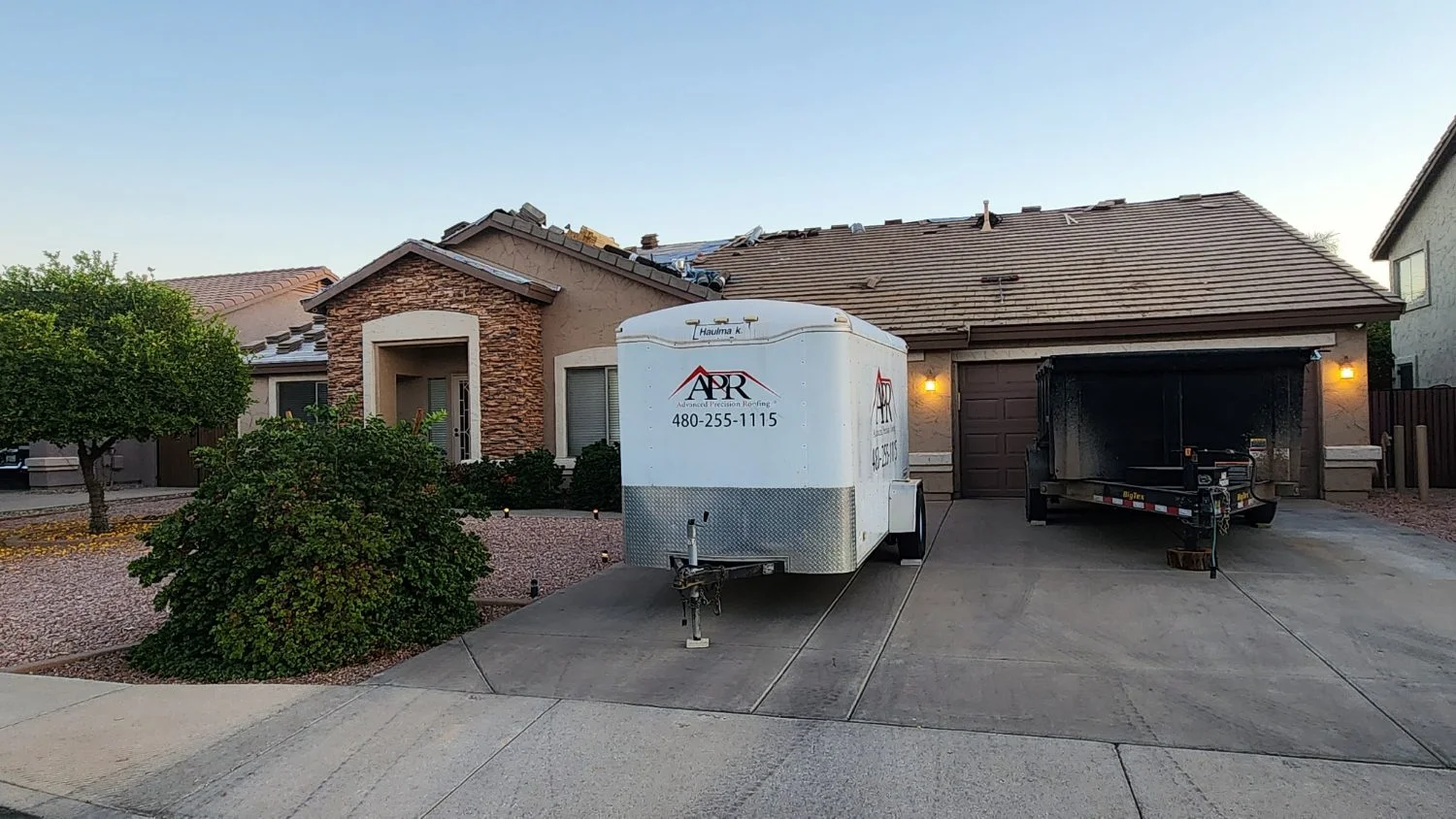 Trailer in a driveway during a tile roof tear-off