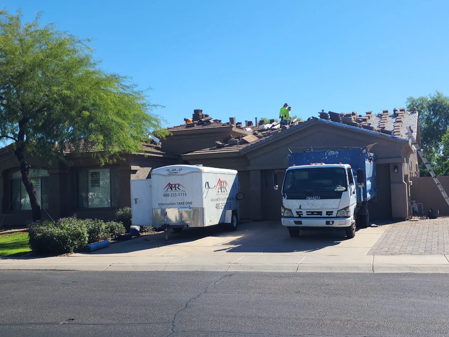 Crew truck and trailer during a tile roof tear-off