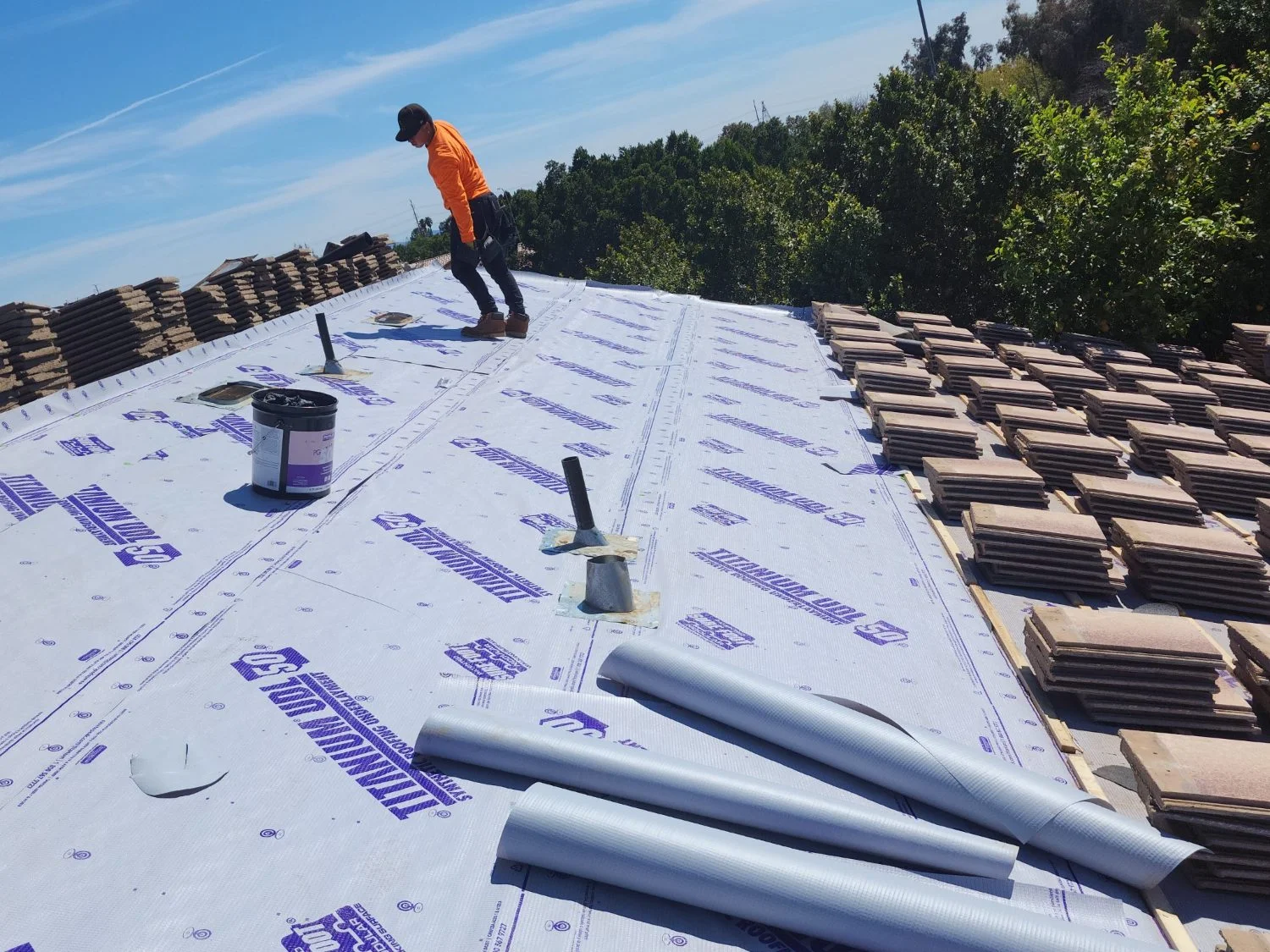 Underlayment being installed with the tile stacked aside